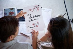 Back view of lovely young couple wrapped up in wedding preparations while gathered together at home