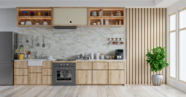 Modern kitchen featuring light oak timber flooring, minimalist cabinetry, and marble backsplash. Includes a stove, sink, and well-organised open shelves, complemented by a large potted plant near bright windows, enhancing the space's natural and contemporary feel.