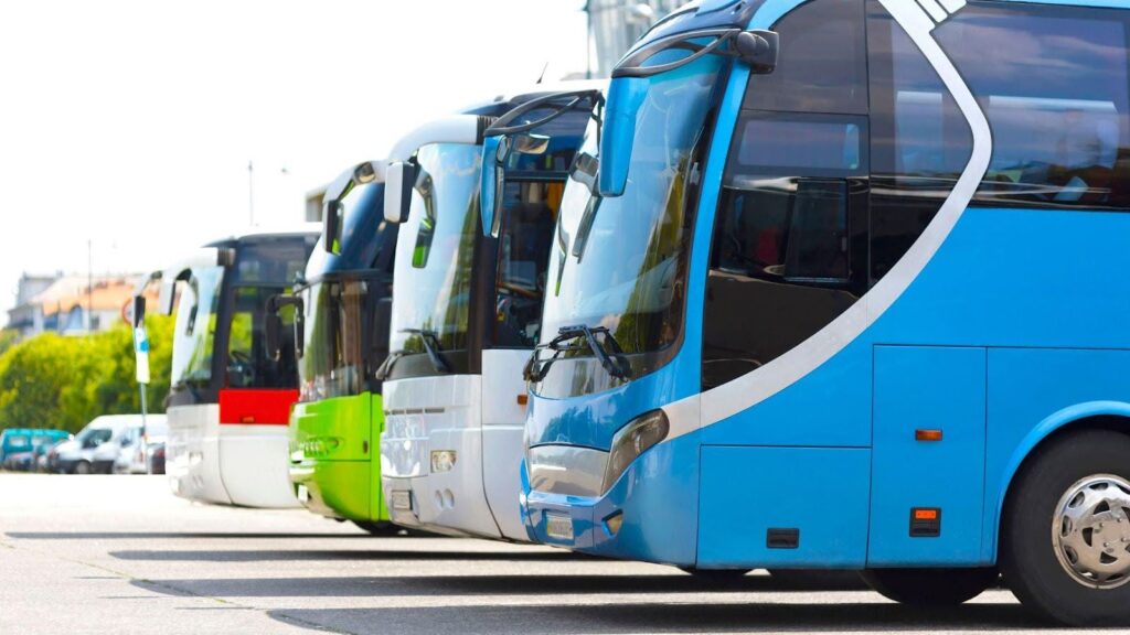 A lineup of modern coaches in various colours parked side by side, illustrating transportation options for sports teams, emphasising safety and style for team travel. 