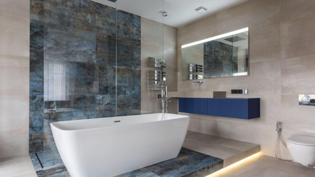 A sleek and modern bathroom featuring a standalone tub, innovative glass shower, and blue vanity, highlighting modern conveniences and design aesthetics.