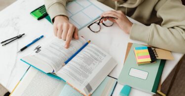 a student studying pointing his finger in the textbook