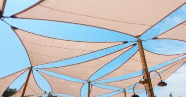 Multiple interconnected shade sails against a clear blue sky, providing cool shade and demonstrating stylish outdoor setup ideas for weekend DIY projects.